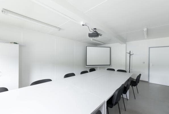 Biela a minimalistická zasadacia miestnosť v projektorom